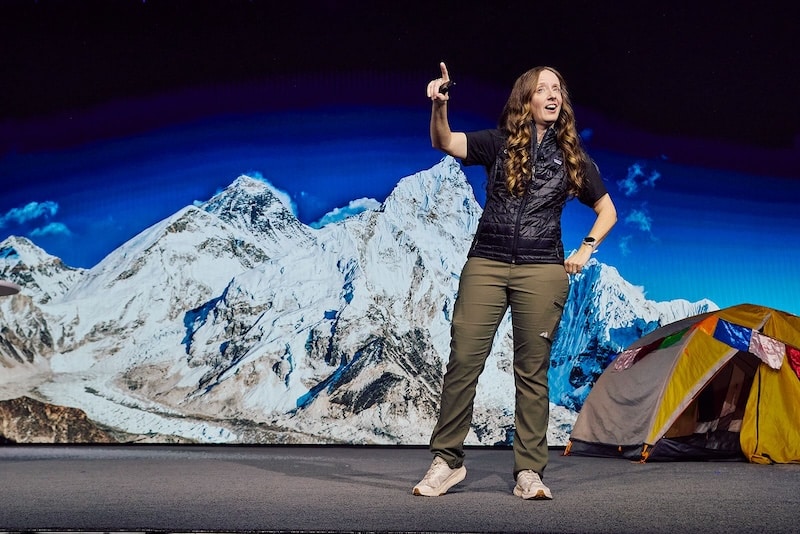 Explore Performance facilitator presenting the For Those Who Dare Everest experience in front of a Himalayan backdrop.